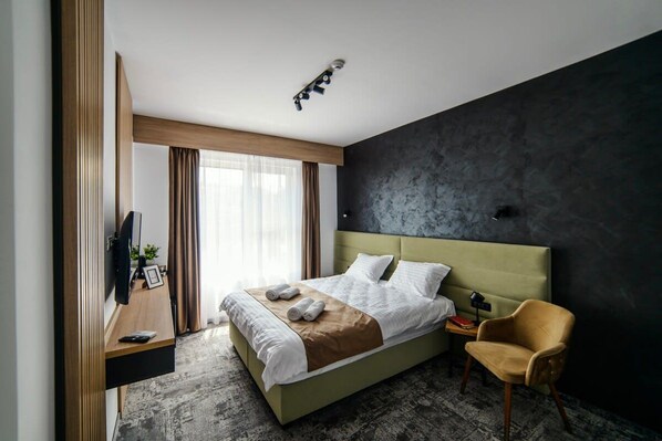A modern hotel room with a bed, a chair, a desk, and a TV. - GBU Home - Olive Tween Room 206 (Timișoara)