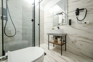 A modern bathroom with a glass shower enclosure, a white toilet, a marble sink, and a mirror above the sink. - GBU Home Azure Room 301 (Timișoara)