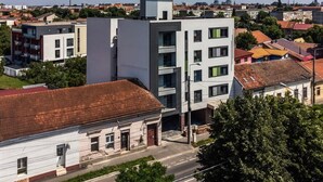 A multi-story building with a flat roof, surrounded by other buildings and greenery. - GBU Home Azure Room 301 (Timișoara)