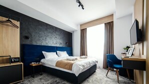 A modern hotel room with a large bed, a desk, a chair, and a wardrobe. - GBU Home Azure Room 301 (Timișoara)