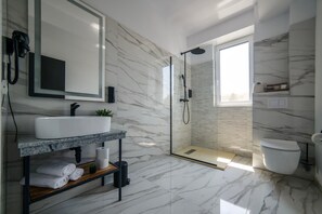 A modern bathroom with a marble floor, a large mirror, a sink, a shower, and a toilet. - GBU Home Timisoara - Olive 302 (Timișoara)