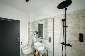 A modern bathroom with a glass partition, a white sink, a mirror, a shower, and a marble wall. - GBU Home Olive Room 306 (Timișoara)