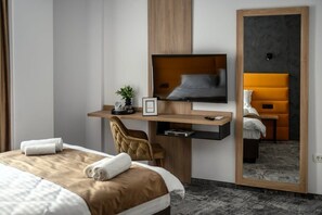 A hotel room with a bed, a desk with a television, a chair, and a mirror. - GBU Home Timisoara Honey 402 (Timișoara)