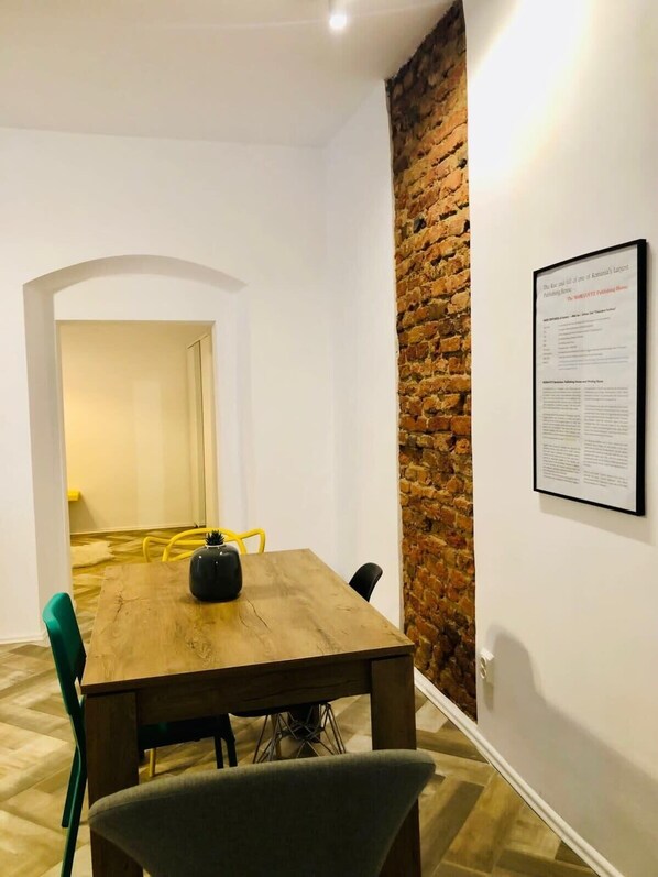 A conference room with a wooden table, chairs, and a brick accent wall.