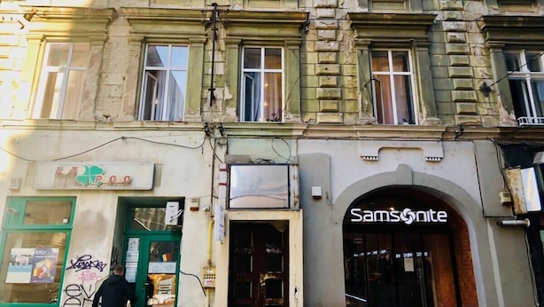 Un edificio con fachada verde y un letrero que dice 'Samsonite'.