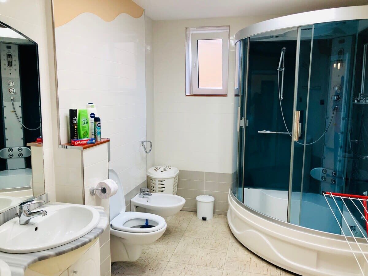 Un baño moderno con ducha acristalada, inodoro, bidé y lavabo.