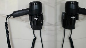 Two hair dryers mounted on a wall with a marble-like surface. - GBU Home Timisoara Olive 407 (Timișoara)