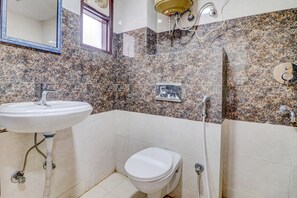 A bathroom with a white sink, toilet, and shower area. - Fabexpress Abode Inn (New Delhi)