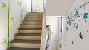 Una escalera adornada con arte mural de bambú y motivos florales.