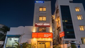Un edificio con un letrero que dice “The Guest House” y “fabHOTELS” en la parte superior.
