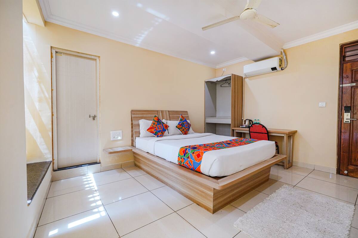 A bedroom with a bed, a desk, a chair, and a wardrobe.