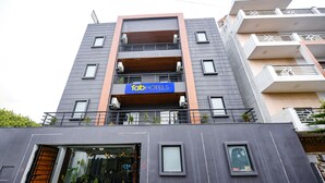 A multi-story building with a sign for 'Fab Hotels'. It has balconies, a glass entrance, and a modern architectural style. - Fabhotel Naina Residency (Rishikesh)