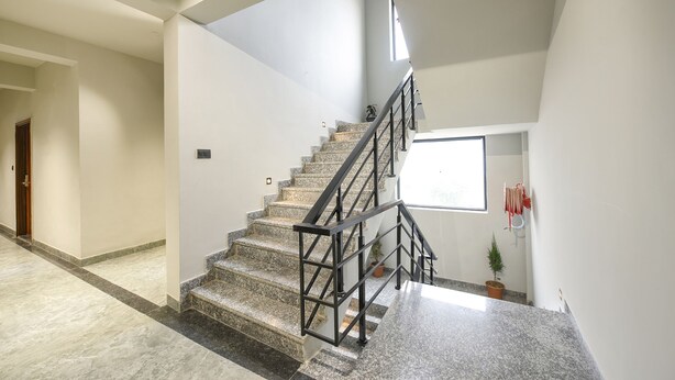 A modern interior with a marble staircase, a small potted plant, and a window providing natural light. - Fabhotel Naina Residency (Rishikesh)