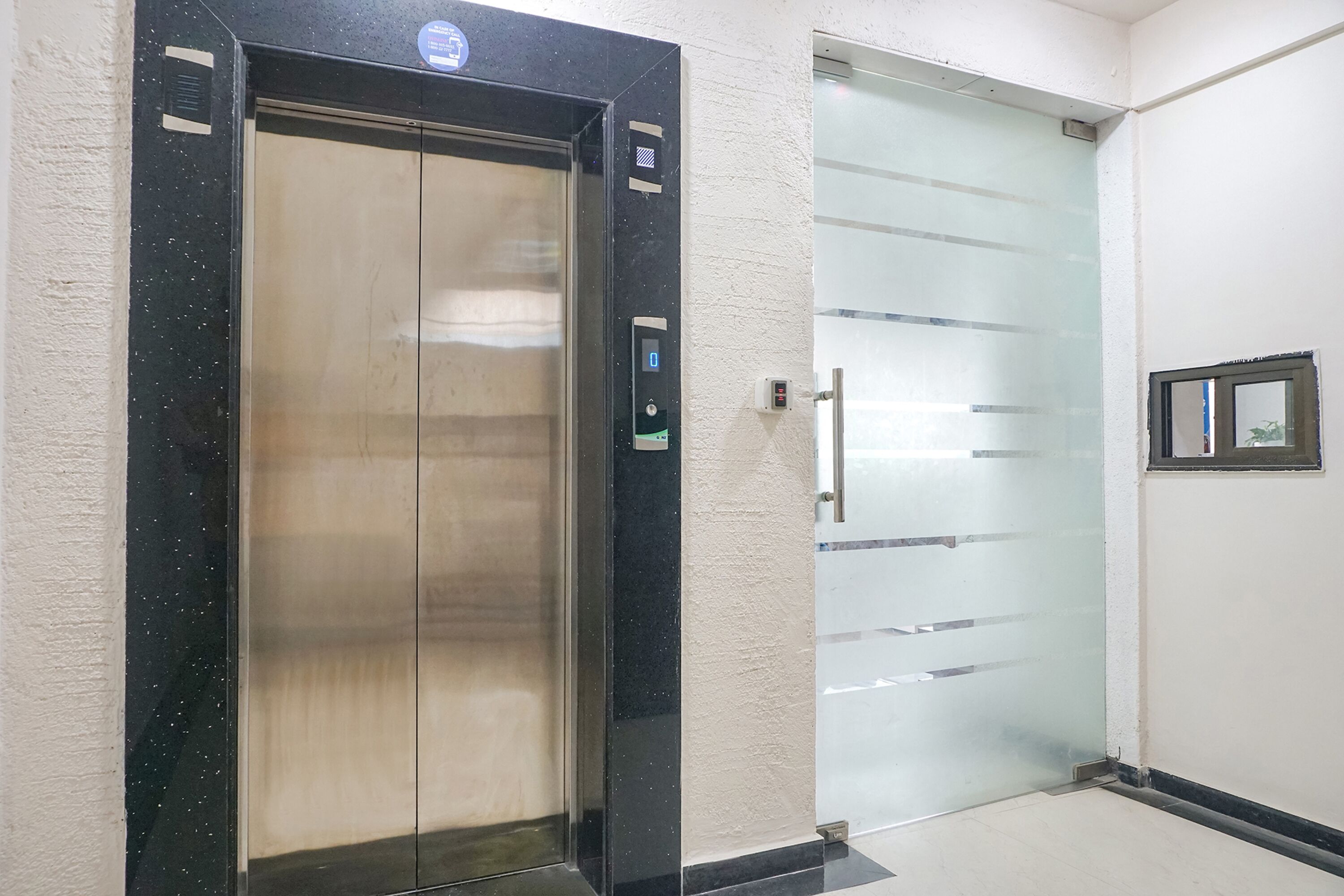 An elevator with a digital display and a glass door.