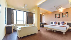 A hotel room with a bed, a desk, a chair, and a window. - FabHotel Apex Intercontinental - Nr. Pink Square Mall (Jaipur)