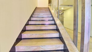 A marble staircase with glass railings leading to a landing. - FabHotel Apex Intercontinental - Nr. Pink Square Mall (Jaipur)