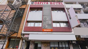 The facade of the Ospite Hotel with a prominent sign, a fire escape, and a visible entrance.