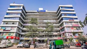 A multi-story building with various commercial establishments on the ground floor, including a hotel named 'fab hotels'. - Fabhotel Sky City (Surat)
