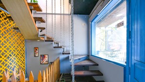 Una escalera de madera con una cadena colgando del techo.