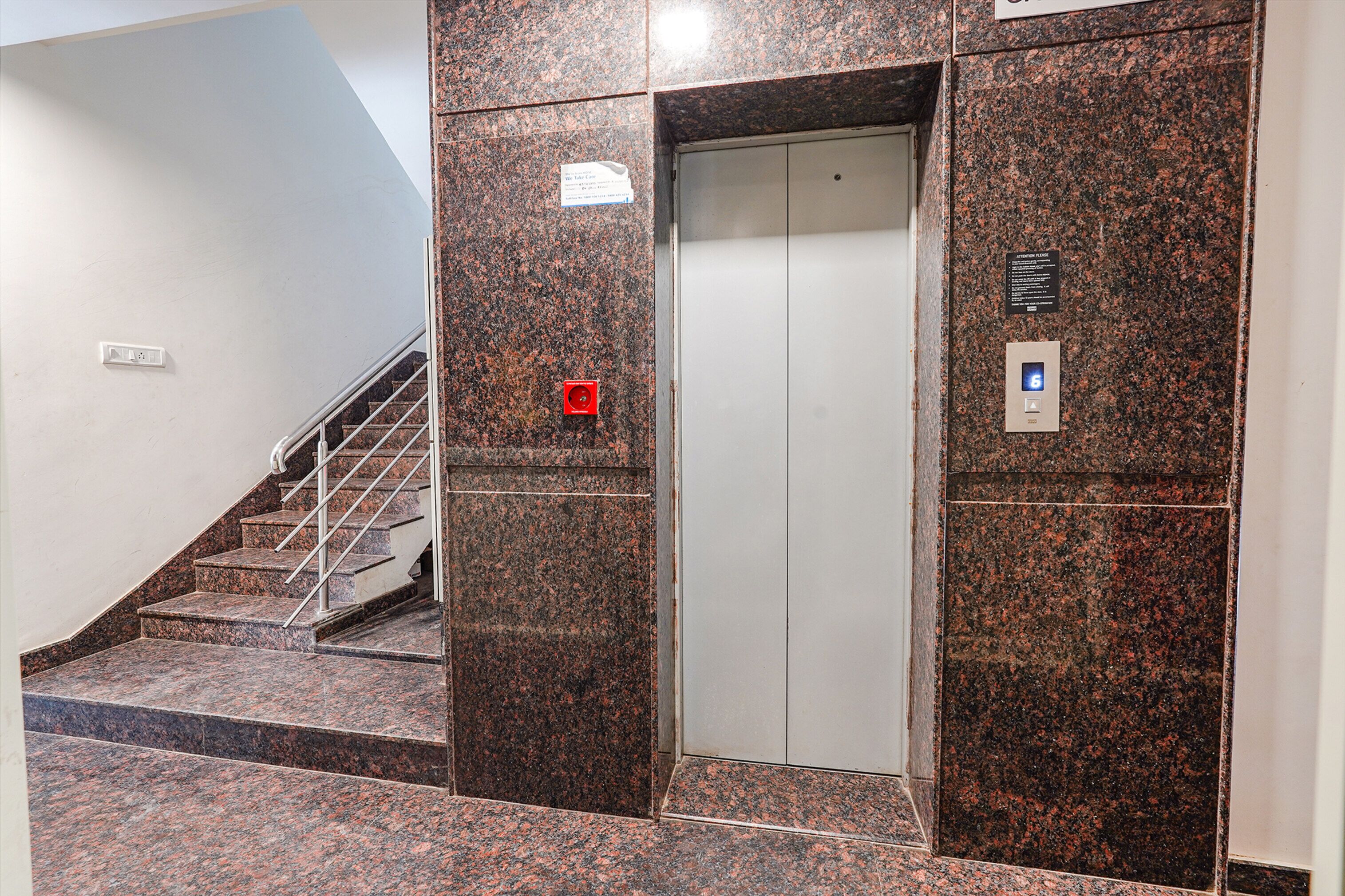 A staircase with a handrail leading to an elevator.
