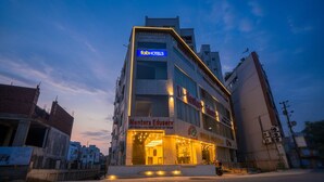 A multi-story building with a sign for 'fobHOTELS' and 'Mentors EduServ'. - FabHotel Icon (Danapur)