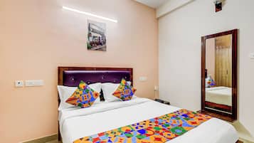 Un dormitorio con una cama, cabecera, espejo e imagen colgada en la pared.