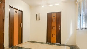 A hallway with two wooden doors, each marked with a number. - Fabhotel Galaxy Residency (Pune)