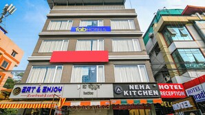 A multi-story building with a 'fab hotels' sign on the top floor, 'eat & enjoh' and 'neha kitchen' on the ground floor, and 'hotel reception' on the right side. - Fabhotel Classic Inn (Indore)