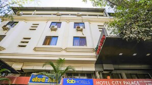Un immeuble à plusieurs étages, sur lequel on peut lire les enseignes « fab hotels » et « Hotel City Palace », indiquant qu’il s’agit d’un hôtel-restaurant.