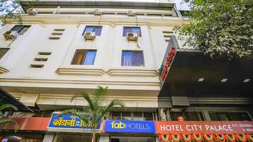 A multi-story building with a sign for 'fab hotels' and 'Hotel City Palace' indicating a hotel and restaurant establishment.