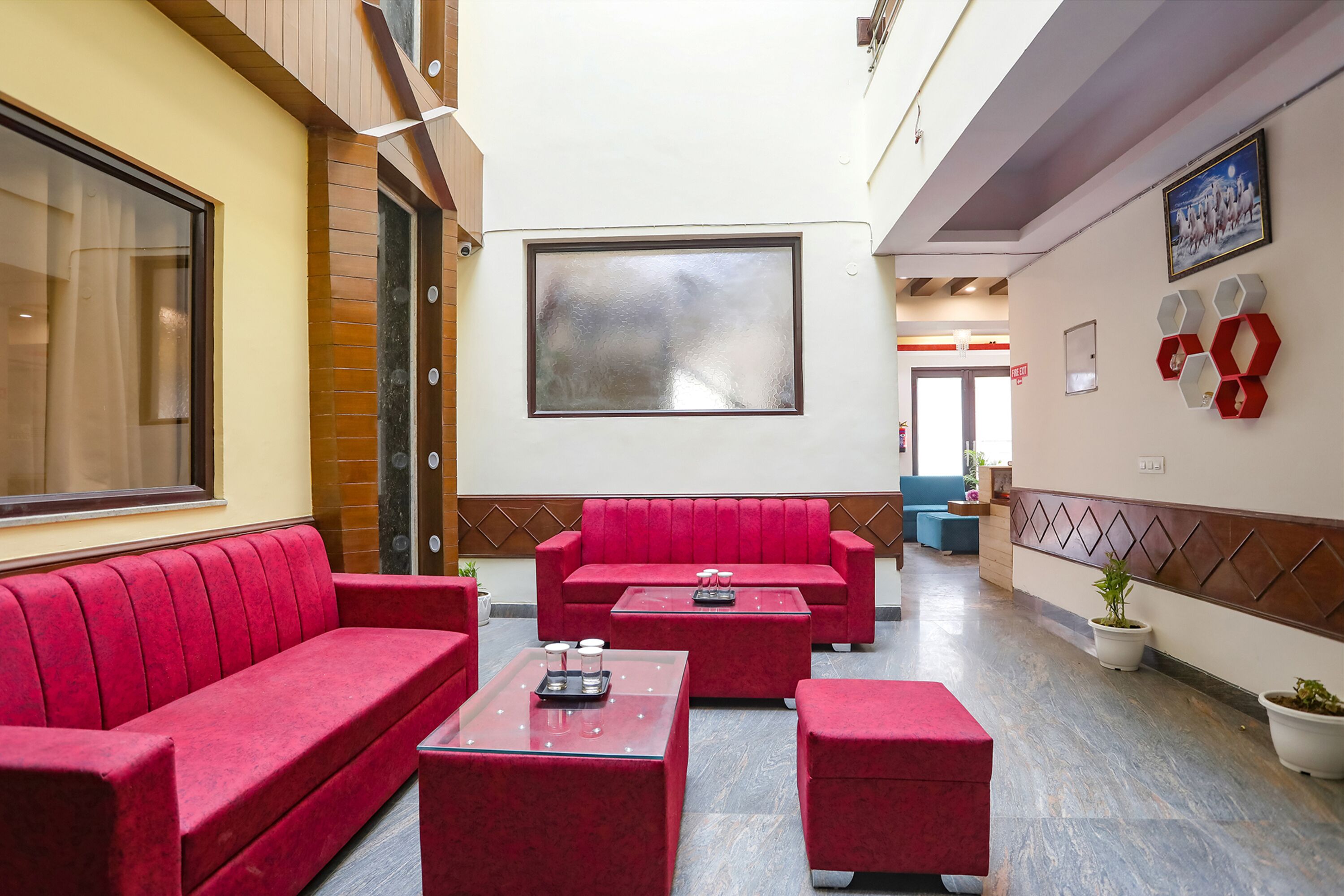 A hotel lobby with red seating, a large window, and a framed picture on the wall.