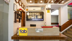 A reception desk with a sign for 'Royal Spark Inn' and a 'fab hotels' sign. - FabHotel The Indian (Gurugram)