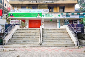 A building with multiple signs, including a pharmacy and a restaurant. - Fabhotel Rvg (Vadodara)