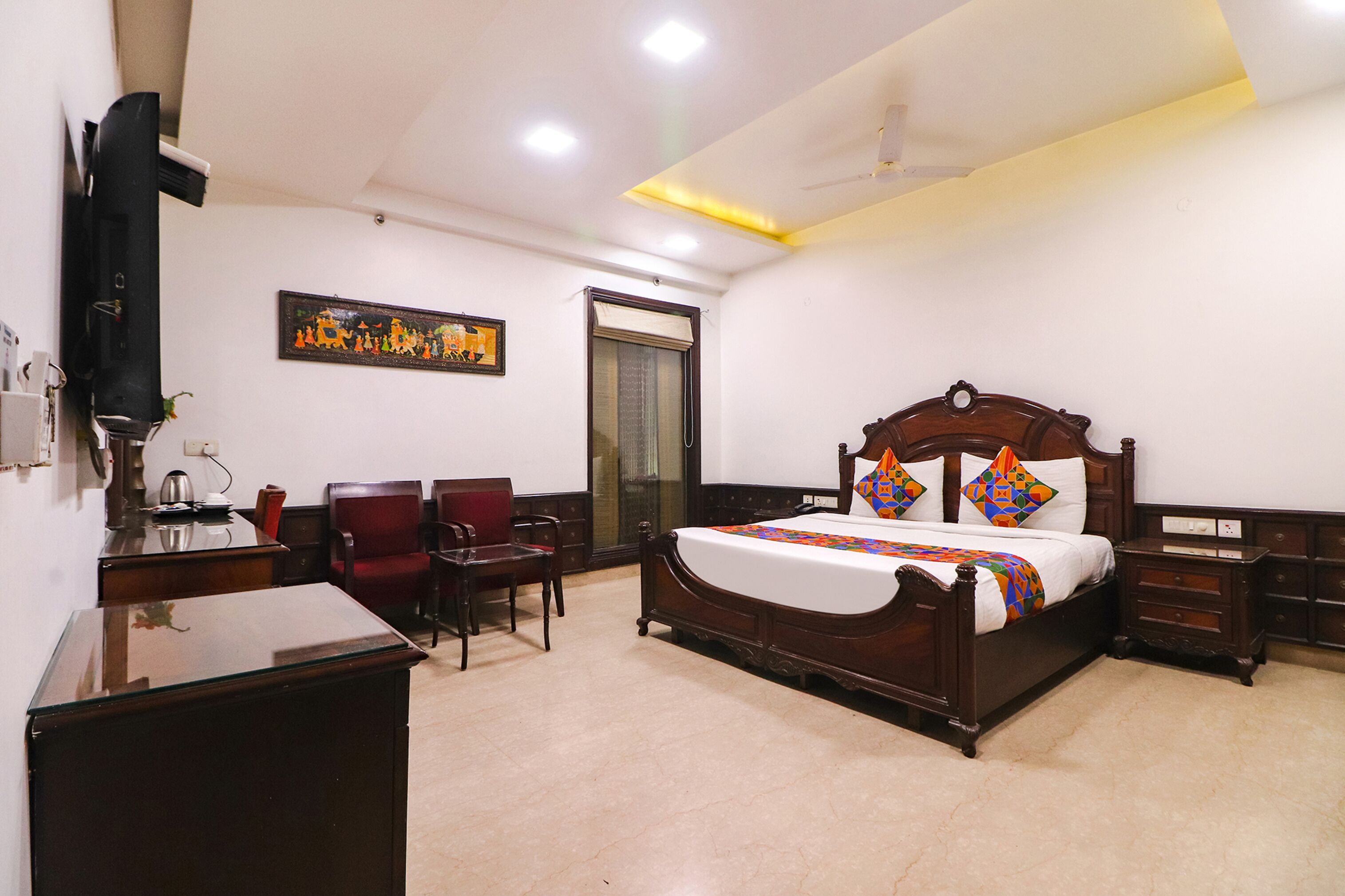 A neatly arranged bedroom with a wooden bed, a desk, and a chair.