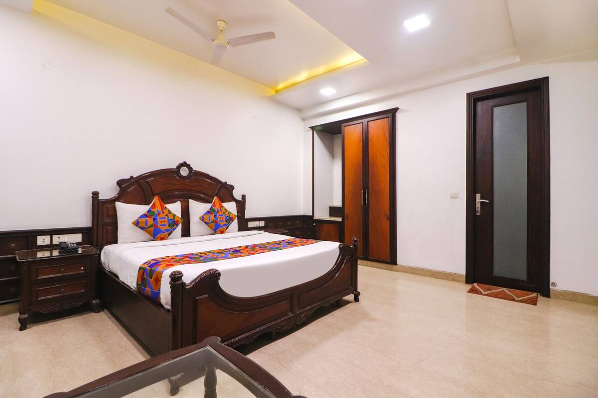 A bedroom with a wooden bed, a nightstand, a wardrobe, and a door.
