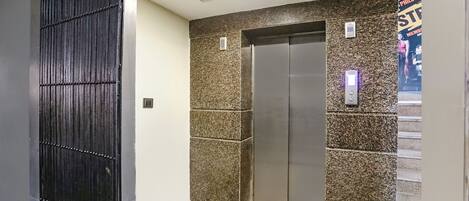 Un ascensor con un panel de control y una pared de diseño moteado.