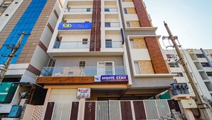 A multi-story hotel with a 'Home Stay' sign, balconies, and a 'fabHOTELS' sign. - Fabhotel Sv Home Stay (Tirupati)