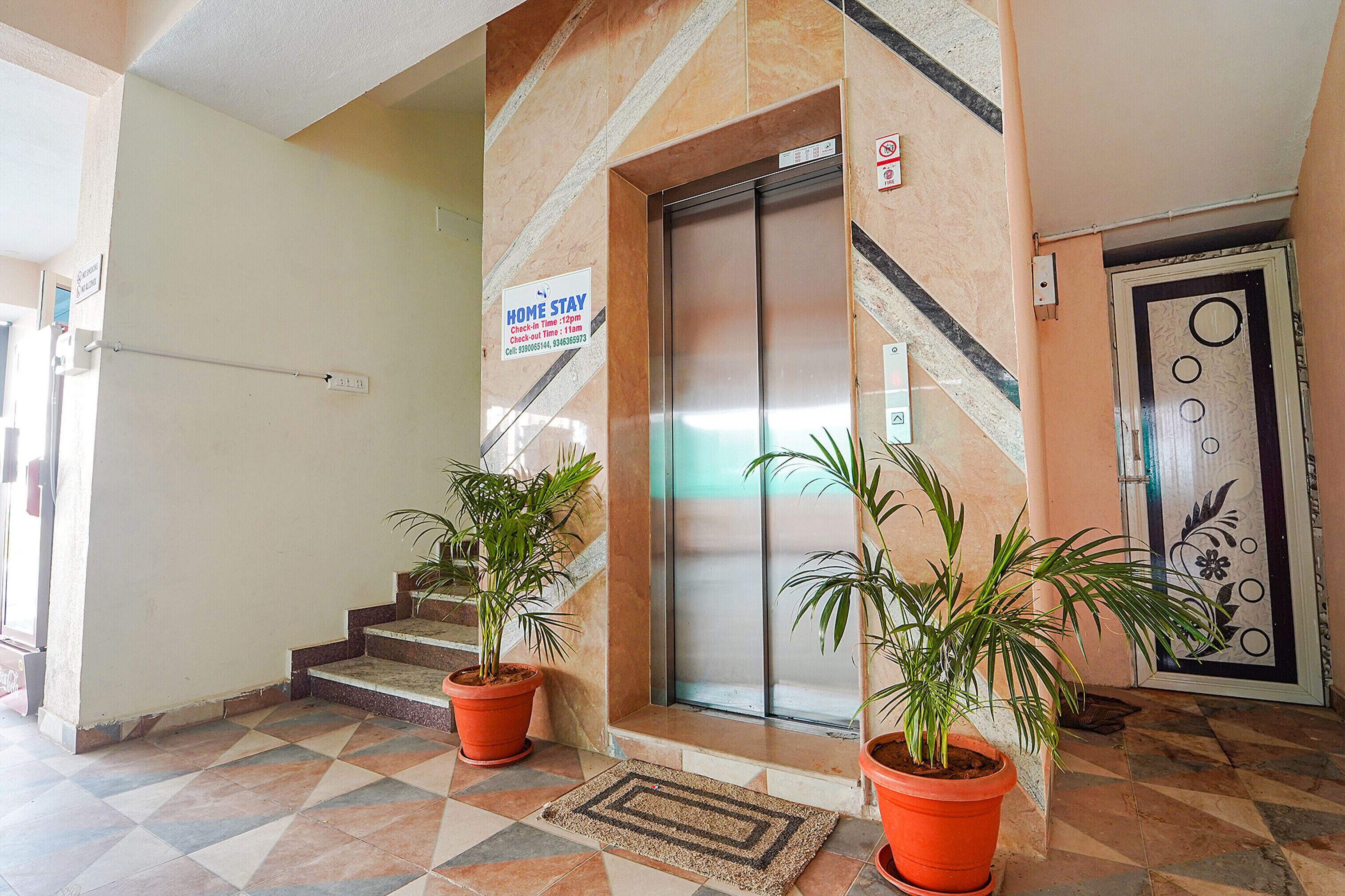An elevator with a sign indicating a home stay check-in time of 11am and 12pm.