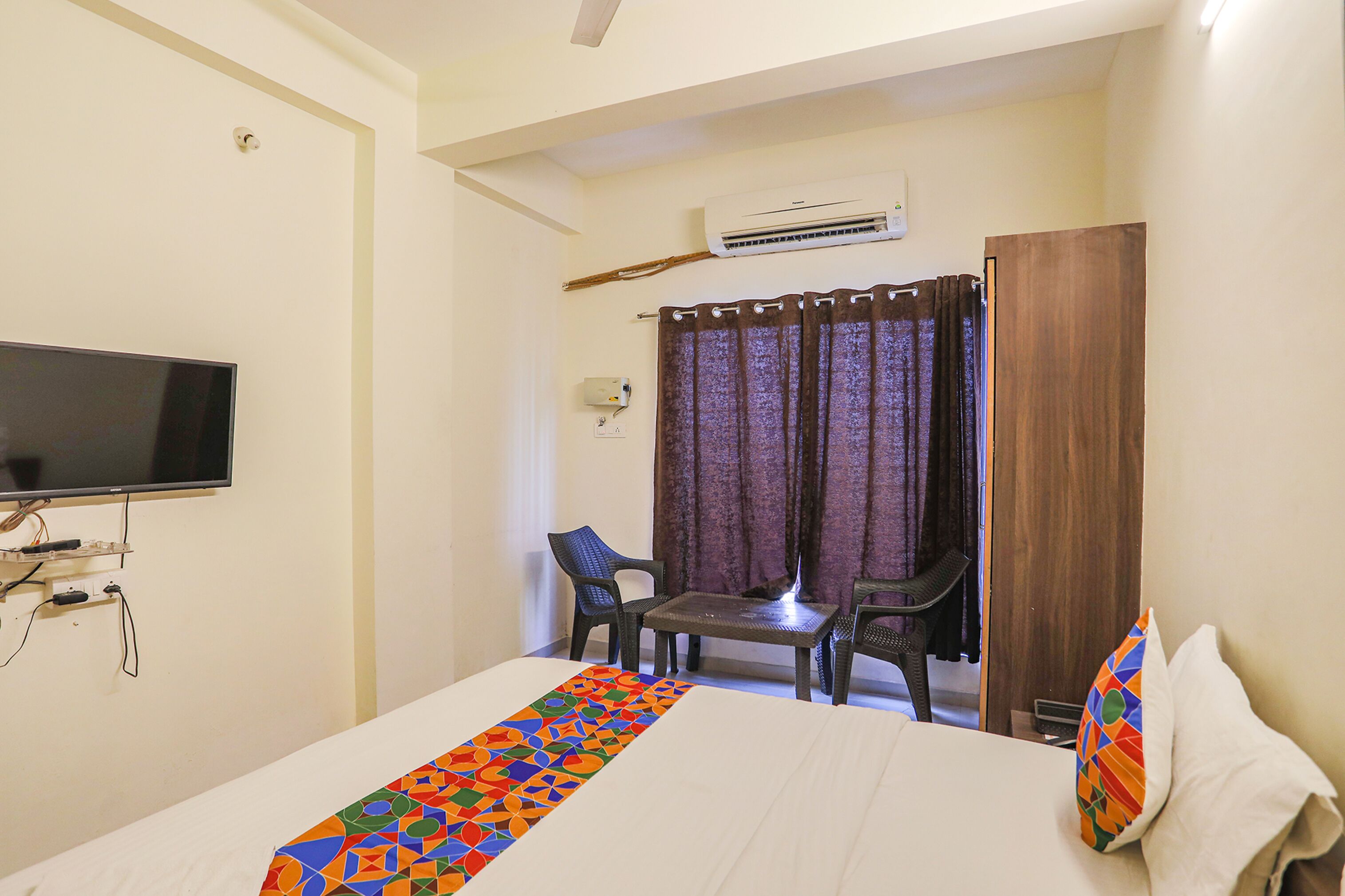 Une chambre d’hôtel avec un lit, une télévision, un bureau et une chaise.