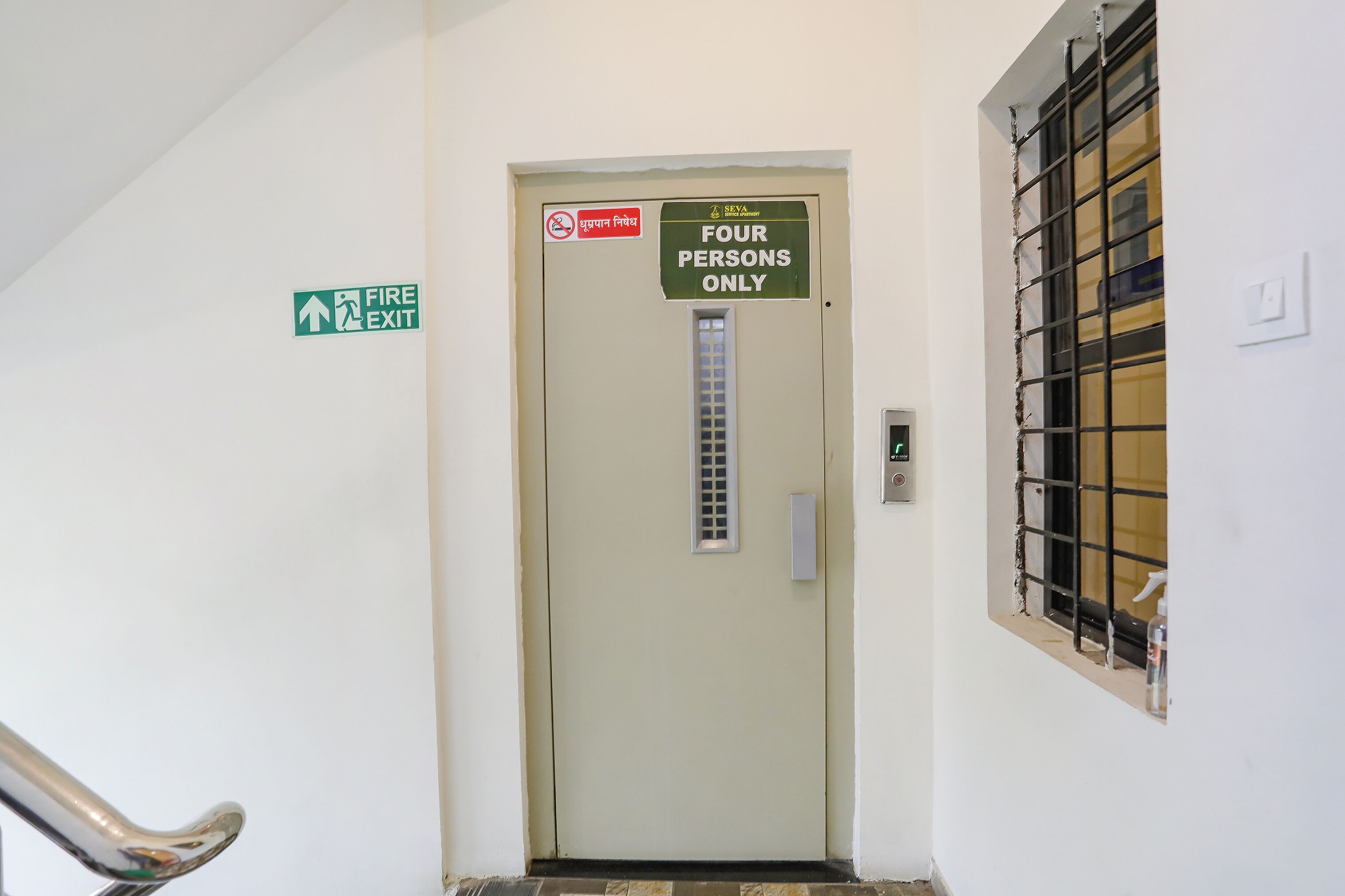 A door with a sign indicating it is for four persons only and a fire exit sign.
