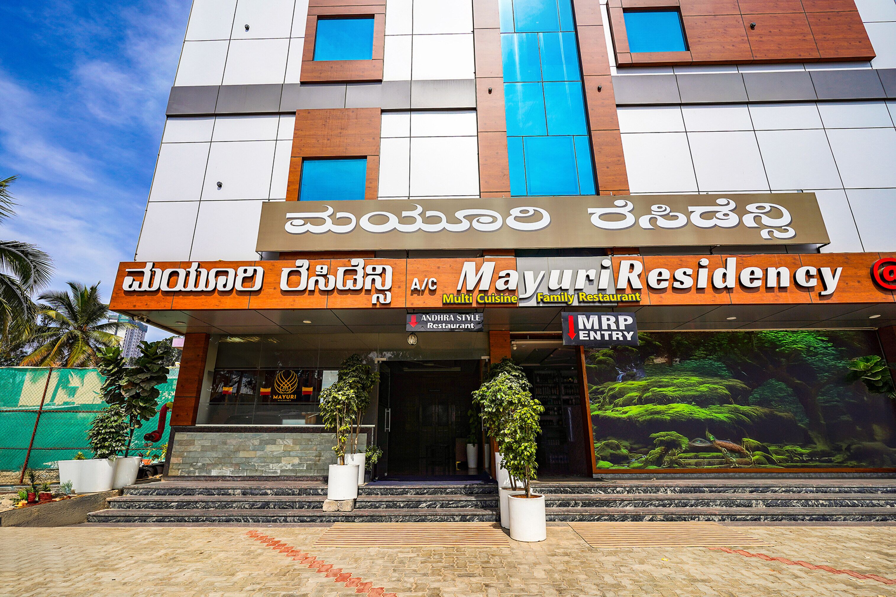 A multi-story building with a sign for MayuriResidency and an MRP Entry.