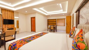 A modern hotel room with a large bed, a desk, a chair, and a TV. - FabHotel Prime Mayuri Residency - Yadavanahalli (Anekal)