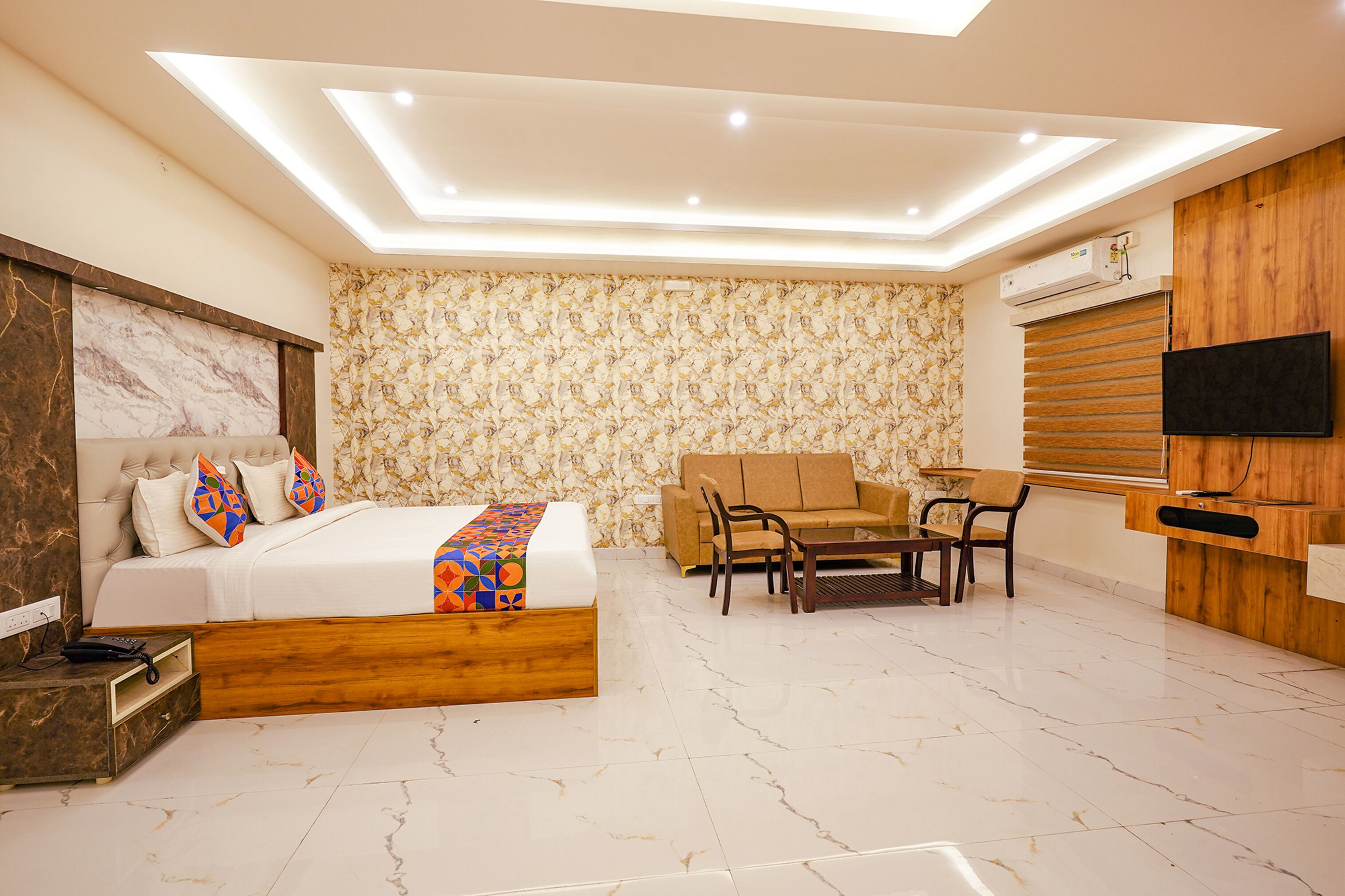 A modern bedroom with a bed, sofa, and TV.