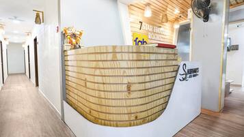 A reception desk with a wooden design, a sign for '7 Star Hotel Rooms', and a 'Shlehan's' sign.