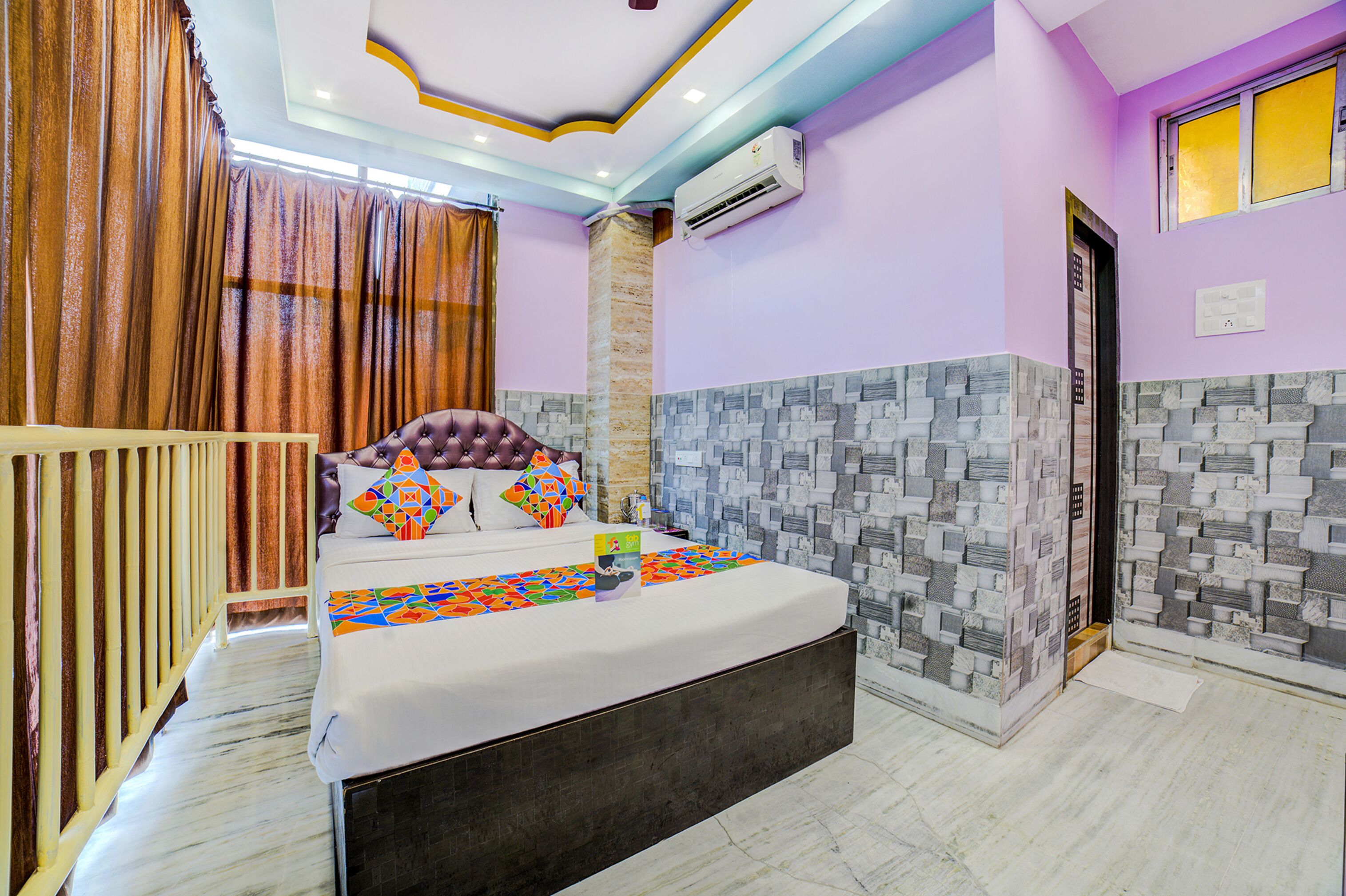 A bedroom with a bed, curtains, an air conditioning unit, and a tiled wall.