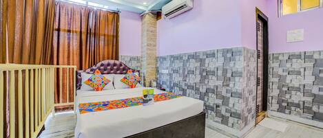 A bedroom with a bed, curtains, an air conditioning unit, and a tiled wall.