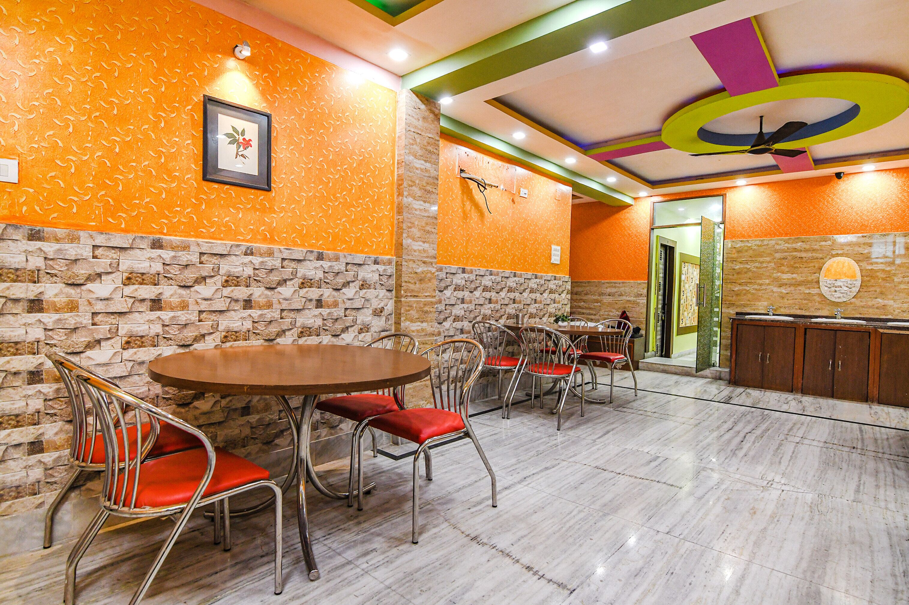 A restaurant with stone walls, orange patterned walls, and a marble floor.