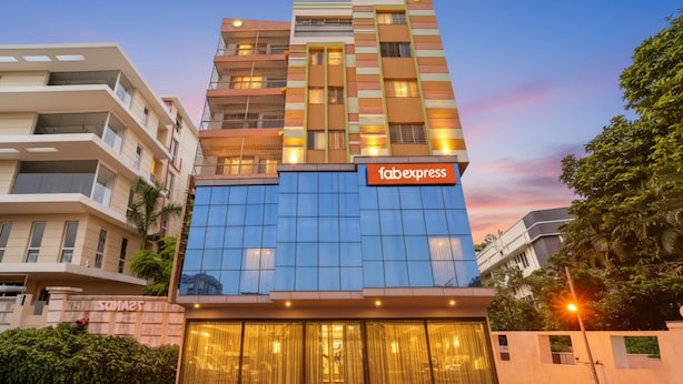 A modern building with a 'fabexpress' sign, featuring a glass facade and multiple balconies. - FabHotel Nest (Kolkata)
