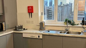 A modern kitchen with a Bosch dishwasher, a stainless steel sink, and a red fire blanket on the wall. - 3-bed Home, Sleeps 8, Ideal for Large Groups (Birmingham)