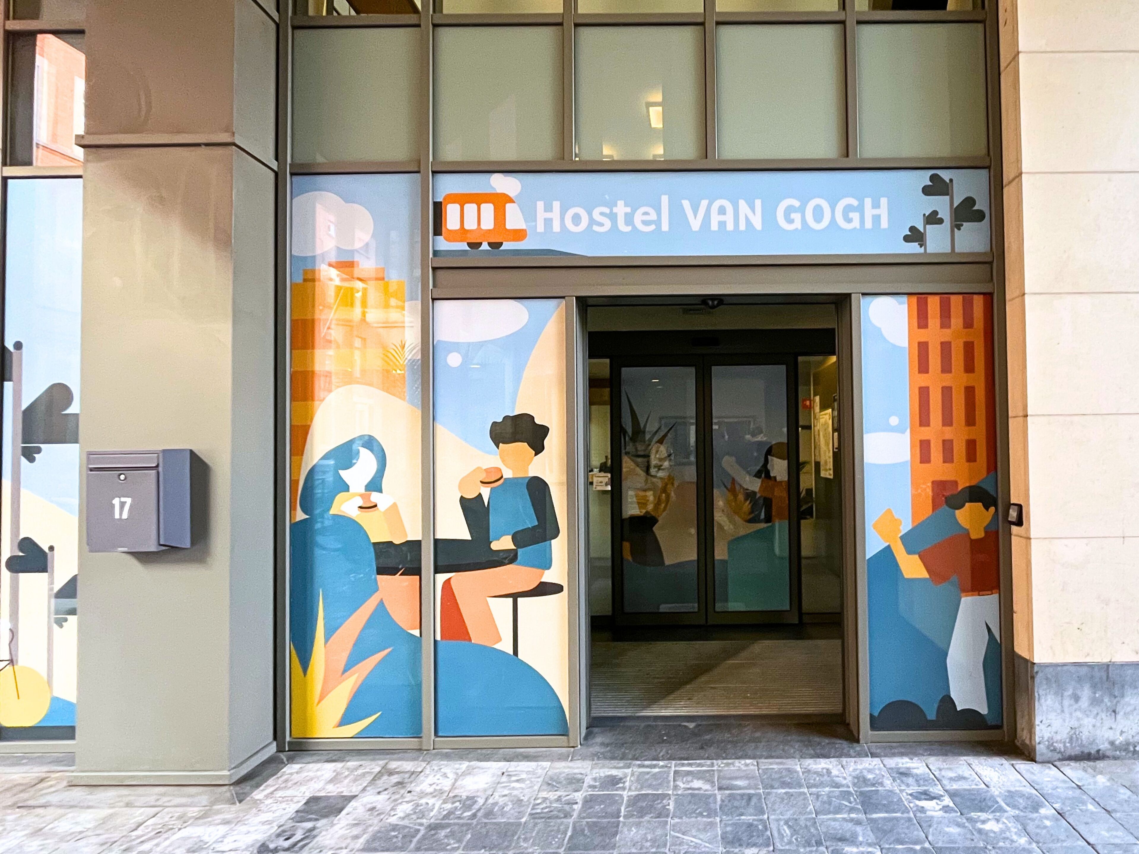 A hostel with a sign reading 'Hostel VAN GOGH' and a door with glass panels.
